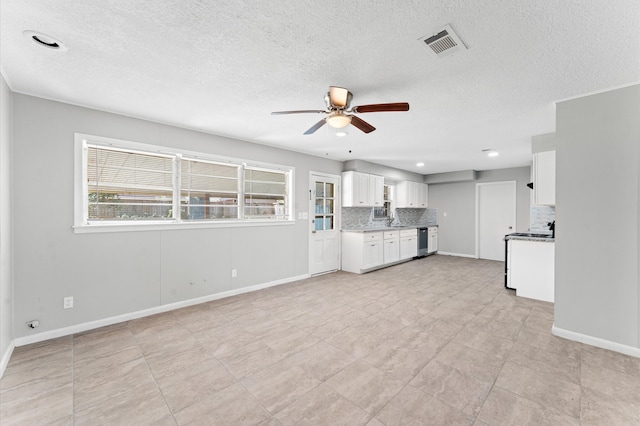 unfurnished living room featuring light tile floors, a textured ceiling, and ceiling fan