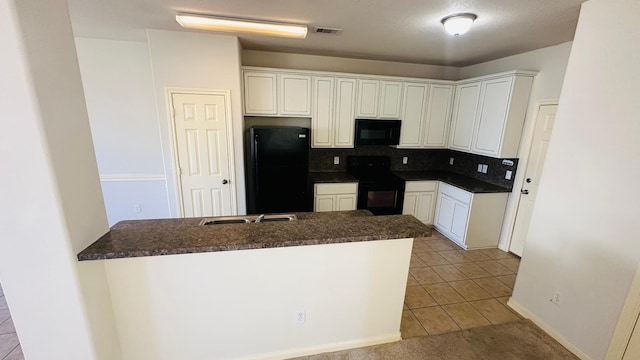 kitchen featuring kitchen peninsula, backsplash, black appliances, and light tile floors