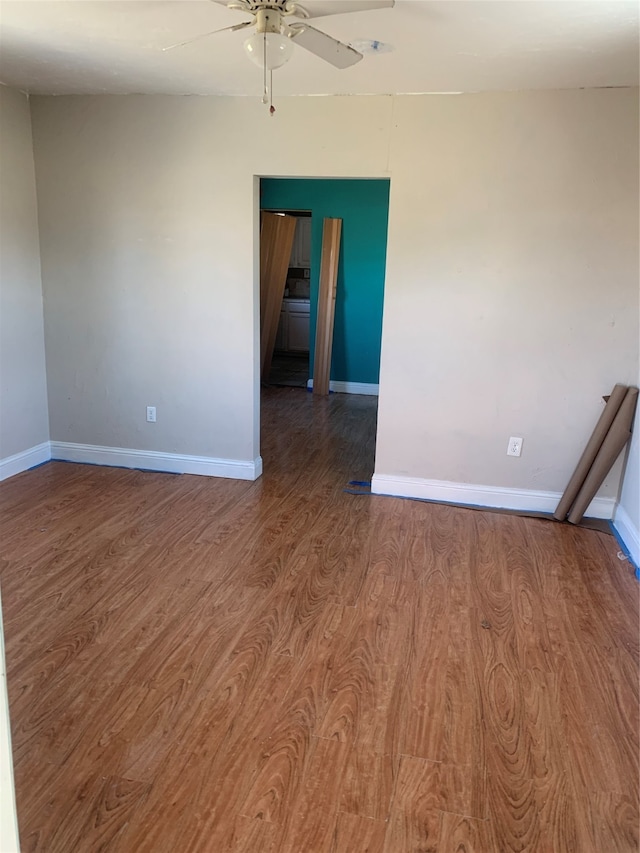 spare room with ceiling fan and dark wood-type flooring