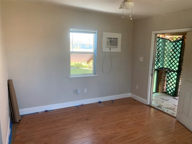 spare room with a wall mounted AC and dark wood-type flooring