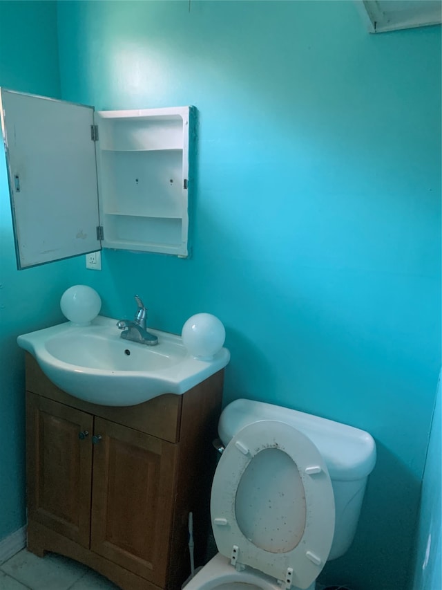 bathroom featuring vanity, tile floors, and toilet