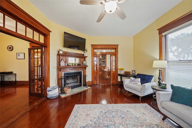 living room with dark hardwood / wood-style flooring and ceiling fan