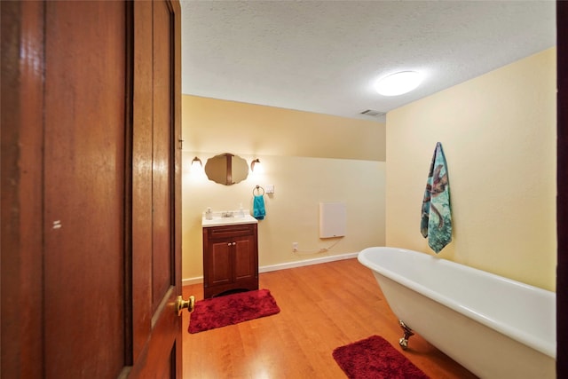 bathroom featuring a bathtub, a textured ceiling, vanity, and hardwood / wood-style flooring