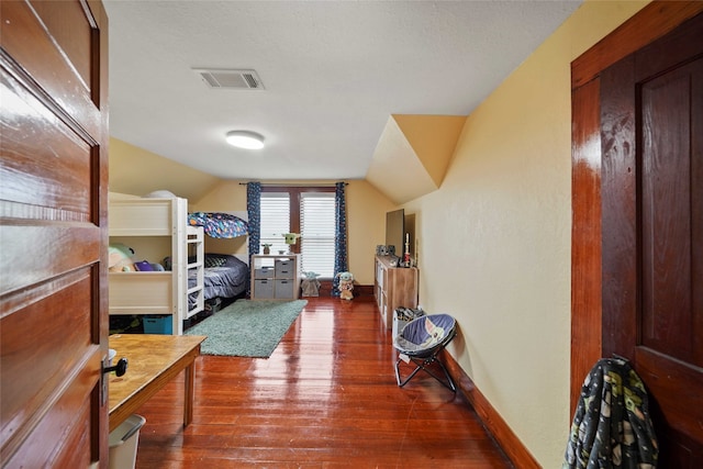 bedroom featuring lofted ceiling and dark hardwood / wood-style flooring