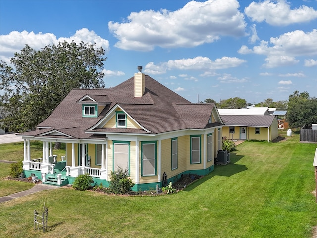 rear view of house with a lawn, central air condition unit, and covered porch