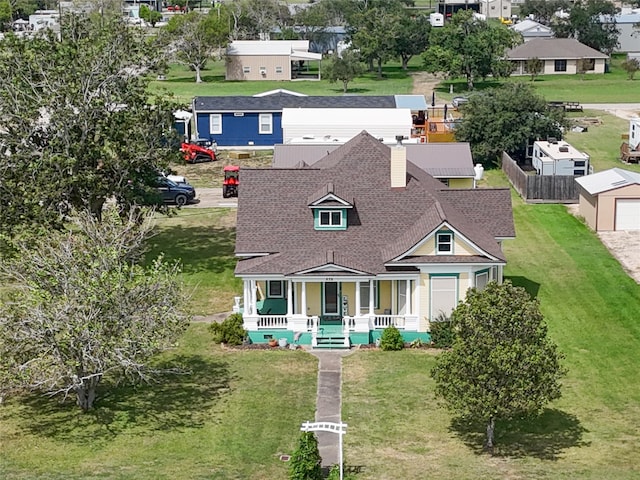 exterior space with a garage, a porch, an outdoor structure, and a front yard