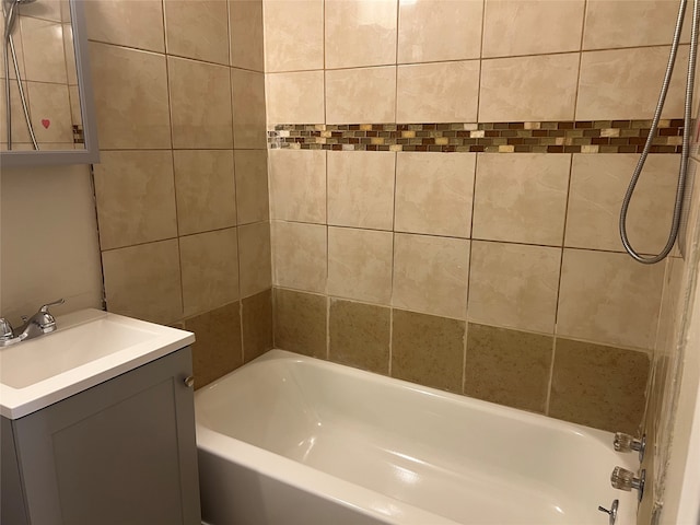 bathroom featuring vanity and tiled shower / bath