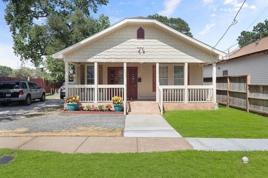 bungalow with a front lawn and covered porch