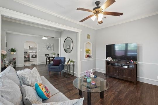 living room with ceiling fan, crown molding, and dark hardwood / wood-style floors