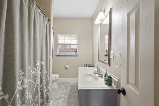 bathroom featuring vanity, tile flooring, and toilet