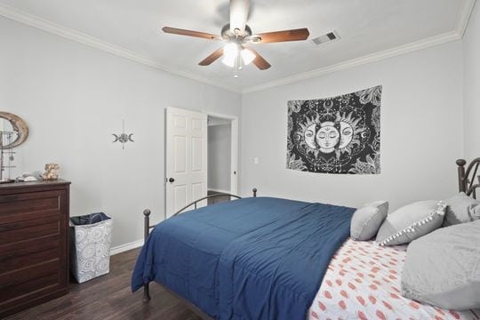 bedroom with ceiling fan, ornamental molding, and dark hardwood / wood-style floors