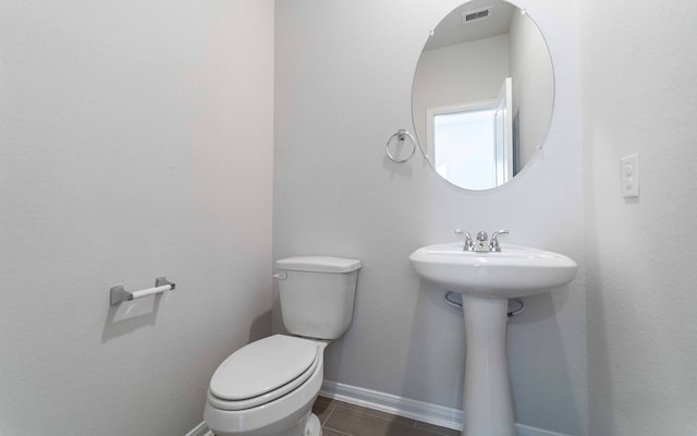 bathroom with toilet and tile patterned flooring