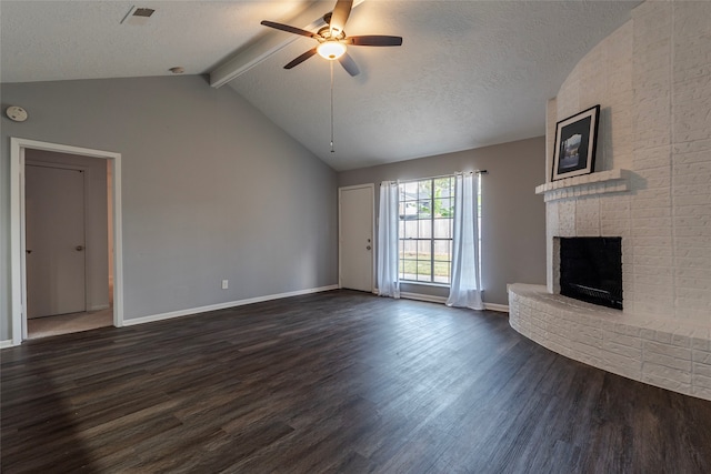 unfurnished living room with lofted ceiling with beams, a brick fireplace, dark hardwood / wood-style flooring, a textured ceiling, and ceiling fan