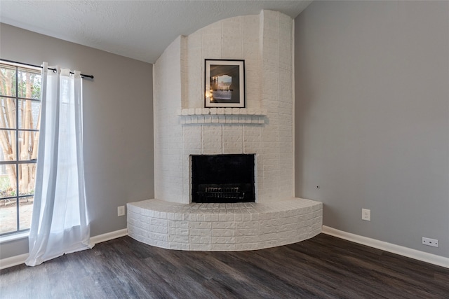 unfurnished living room featuring dark hardwood / wood-style floors, a textured ceiling, and plenty of natural light