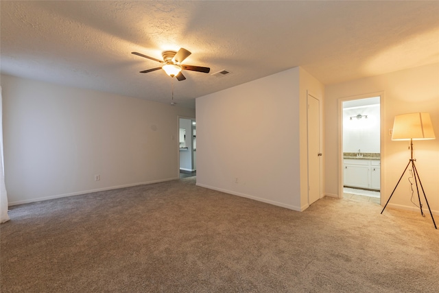 spare room with light carpet, a textured ceiling, and ceiling fan