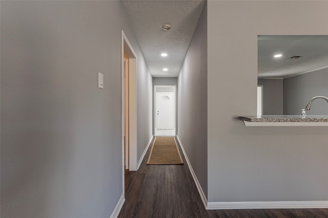 hall featuring a textured ceiling and dark hardwood / wood-style flooring