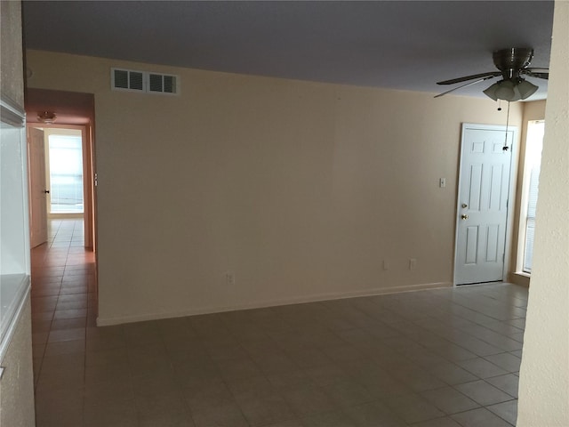 empty room featuring visible vents, baseboards, and ceiling fan