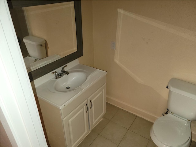 bathroom featuring tile patterned flooring, toilet, vanity, and baseboards