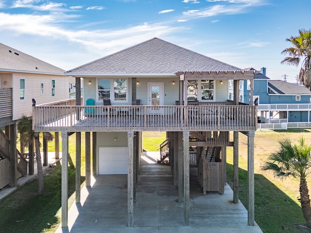 back of house with a garage, a carport, and a porch