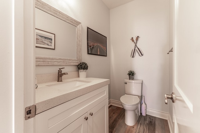 bathroom with hardwood / wood-style floors, toilet, and vanity