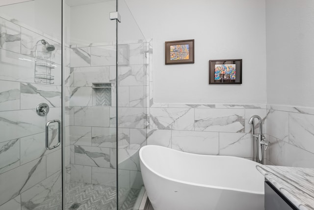 bathroom with tile walls, vanity, and independent shower and bath