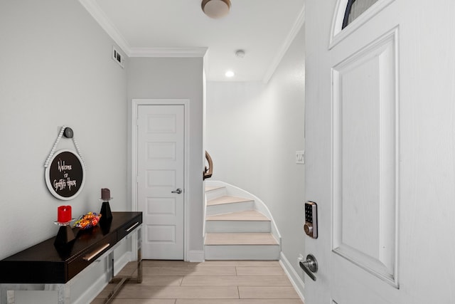 mudroom with ornamental molding and light wood-type flooring