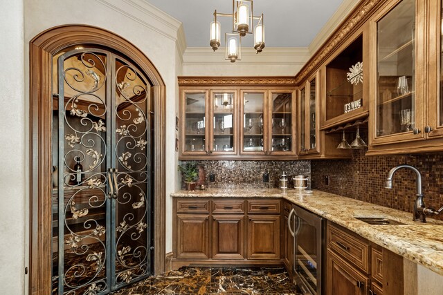 interior space featuring an inviting chandelier, hanging light fixtures, light stone counters, backsplash, and sink