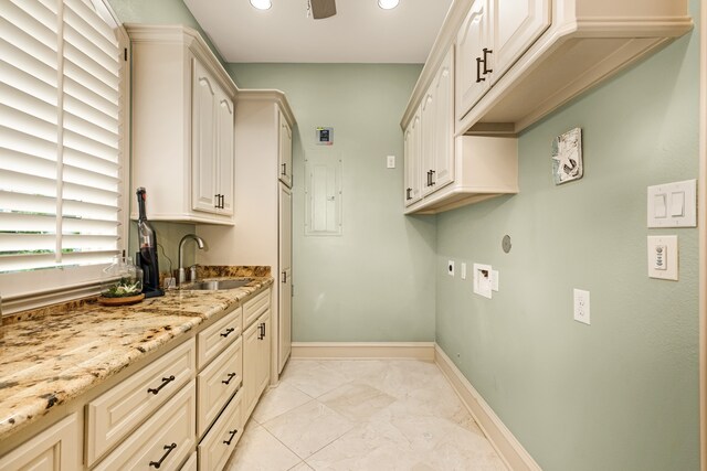 washroom featuring cabinets, hookup for an electric dryer, sink, and light tile flooring