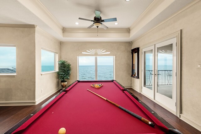 rec room with ceiling fan, a raised ceiling, billiards, hardwood / wood-style flooring, and crown molding