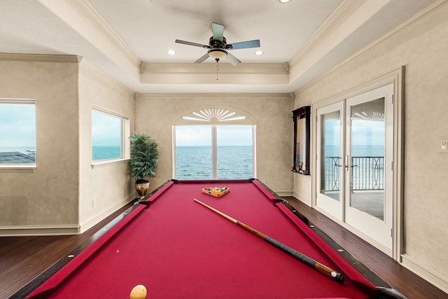 recreation room with ceiling fan, a water view, wood-type flooring, ornamental molding, and pool table