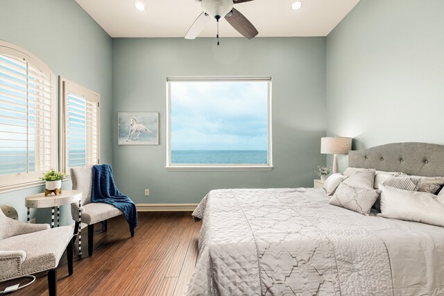 bedroom featuring a water view, ceiling fan, and dark hardwood / wood-style floors