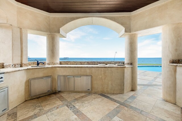 view of terrace with a water view, area for grilling, and sink