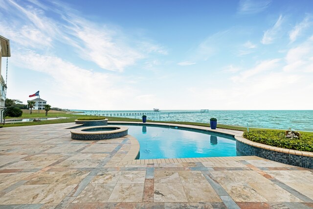 view of pool with a water view, a patio area, and an in ground hot tub