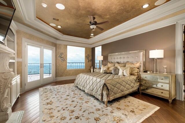 bedroom featuring a raised ceiling, dark wood-type flooring, ceiling fan, and access to outside