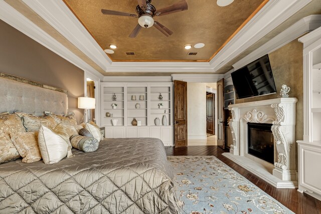 bedroom featuring crown molding, a raised ceiling, ceiling fan, and dark hardwood / wood-style flooring