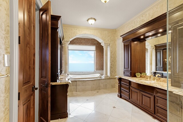 bathroom featuring tile floors, a relaxing tiled bath, vanity, ornamental molding, and ornate columns