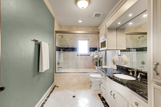 full bathroom with bath / shower combo with glass door, crown molding, toilet, vanity, and tile floors