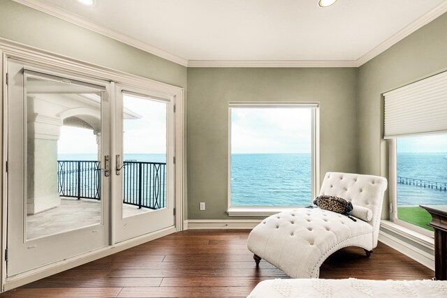 sitting room with a water view, dark hardwood / wood-style floors, and a healthy amount of sunlight