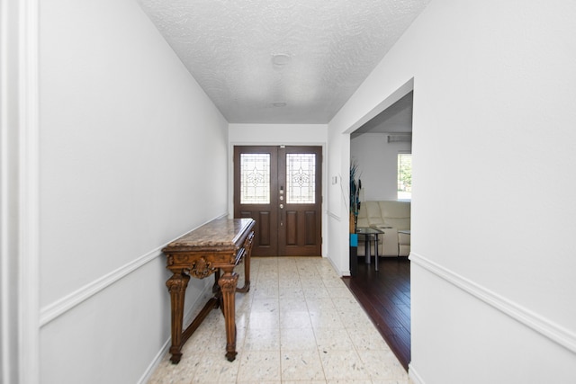 foyer with a textured ceiling and tile flooring