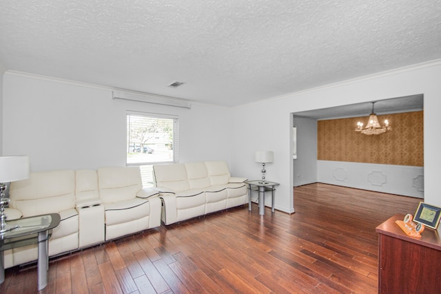 living room featuring crown molding, a textured ceiling, dark hardwood / wood-style flooring, and a notable chandelier