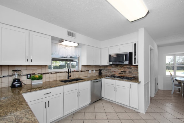 kitchen featuring white cabinets, appliances with stainless steel finishes, tasteful backsplash, and sink