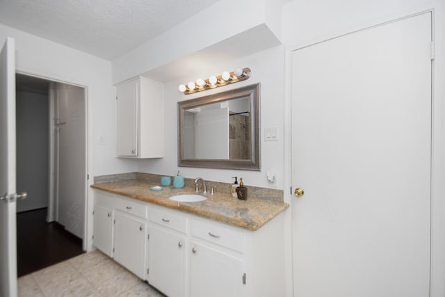 bathroom featuring tile floors, a textured ceiling, and vanity