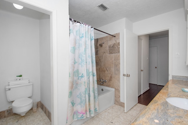 full bathroom with toilet, shower / bath combo, a textured ceiling, tile floors, and sink