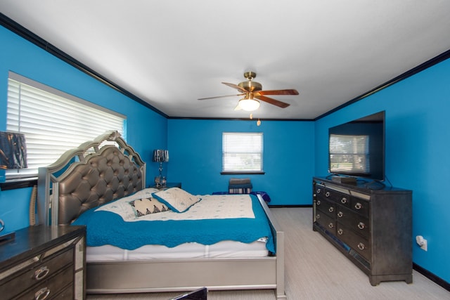 carpeted bedroom featuring ceiling fan and crown molding