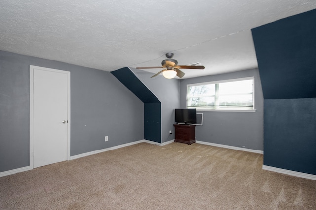 bonus room featuring light carpet, vaulted ceiling, a textured ceiling, and ceiling fan