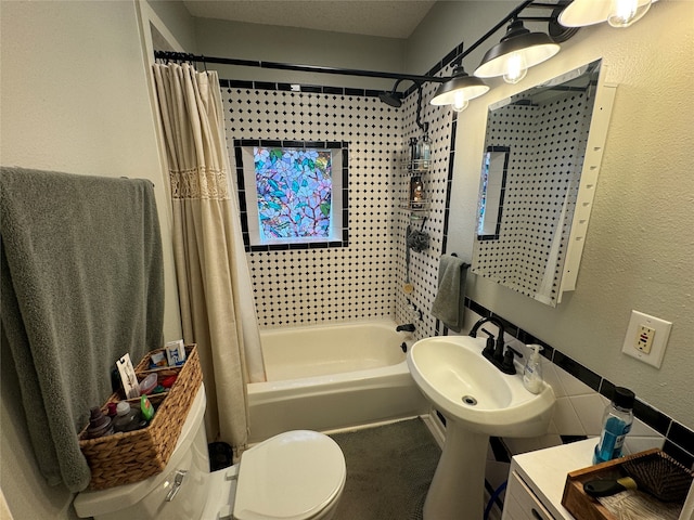 full bathroom featuring sink, shower / bath combination with curtain, and toilet