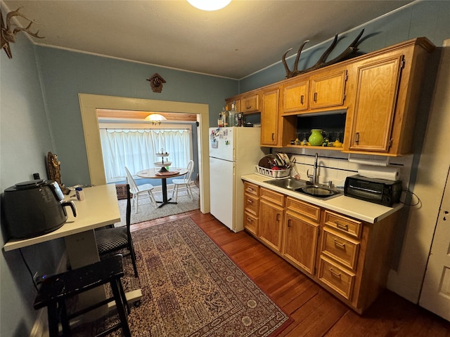 kitchen featuring white fridge, tasteful backsplash, crown molding, dark wood-type flooring, and sink