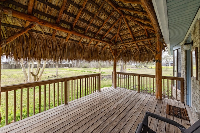 wooden deck with a lawn and a gazebo