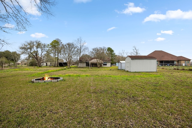 view of yard featuring a storage shed and an outdoor fire pit