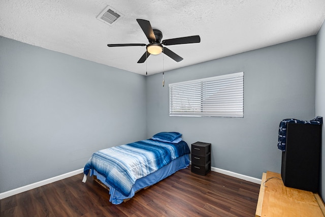 bedroom featuring a textured ceiling, ceiling fan, and dark hardwood / wood-style floors